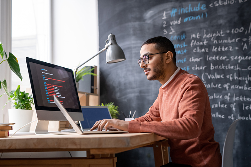 it-manager-sitting-in-front-of-laptop-in-office-an-RVGUTVZ